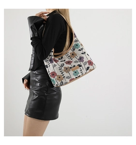 Detail of floral canvas tote bag showing colorful flower patterns and brown leather straps
