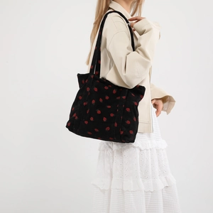 Borsa tote in velluto a coste nero con ricami di fragole rosse e doppi manici