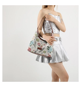 Détail du sac bandoulière en toile brodée de fleurs avec bandoulière en cuir marron