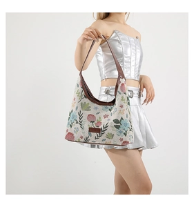Close-up of floral jacquard fabric texture and leather strap on hobo shoulder bag
