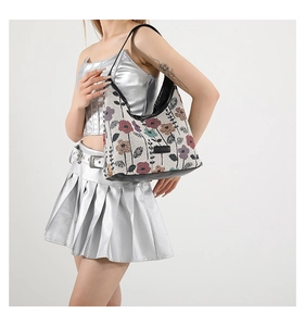 Détail du tissu jacquard floral vintage sur sac hobo avec bordures en cuir noir