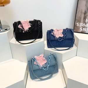 Three denim shoulder bags in black, dark blue, and light blue with pink star patches