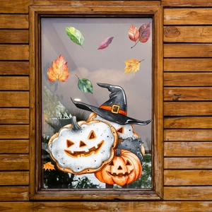 Dettaglio di vetrofanie Halloween con zucca e foglie di acero su una finestra di vetro