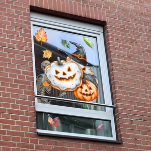 Adesivi per finestre di Halloween con zucche e foglie d'acero su un vetro