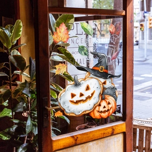 Adesivi per finestre di Halloween con zucche ad acquerello e foglie d'acero su porta a vetri