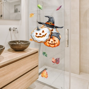 Dettaglio di adesivi zucca di Halloween e foglie autunnali su porta in vetro