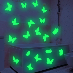 Detailed view of luminous butterfly wall stickers glowing in a dark bathroom setting