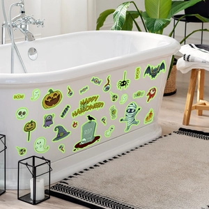 Luminous Halloween stickers on bathtub showing glowing pumpkins and ghosts in dark