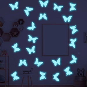 Luminous blue butterfly wall stickers with glowing 3D wings in a dark bedroom setting