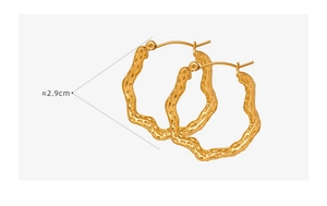 Detail shot of gold-plated titanium steel hoop earrings with textured lava pattern