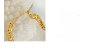 Detailed macro view of gold irregular textured hoop earrings with a lava molten finish