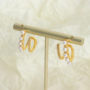 French style gold spiral earrings with pearls and crystals on a display stand