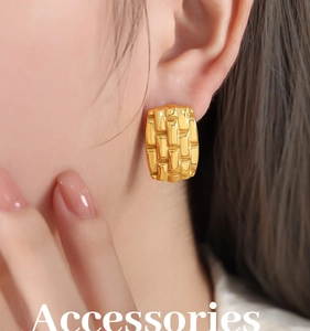 Macro shot of gold square textured earrings with geometric pattern on skin
