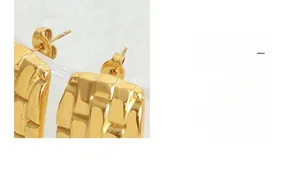 Close-up of golden rectangular earrings featuring a textured 3D geometric woven pattern