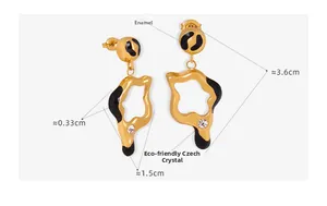 Detail of gold geometric hollow earrings with black drip oil and Czech crystal accents