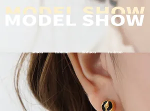 Macro detail of gold-plated stud earring with black enamel yin yang pattern design