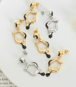 Detailed shot of irregular geometric star earrings with black enamel and rhinestones