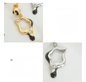 Close-up of 18K gold plated titanium steel star earrings with black oil drip and crystal