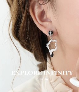 Detailed view of silver star earrings with black enamel and zircons on a model