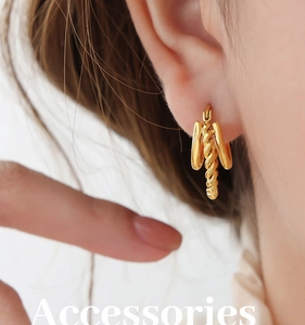 Gros plan détaillé des boucles d'oreilles torsadées dorées avec design géométrique bohème
