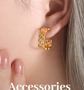 Macro side view of a model wearing vintage gold hollow lattice hoop earrings with crystals