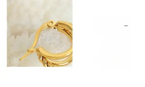 Gros plan de boucles d'oreilles multicouches torsadées dorées au fini texturé vintage