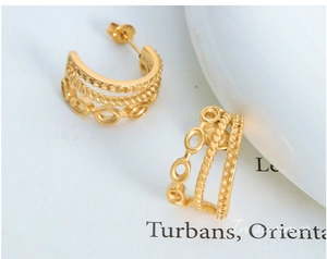 Detailed close-up of triple-layered gold C-shape earrings with vintage textures