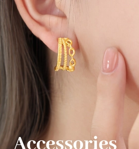 Close-up of triple-layered gold-plated hoop earrings with textured weaving patterns