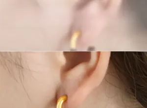 Close-up of a French vintage U-shaped gold hoop earring worn by a model on the ear