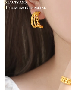 Close-up of twisted woven design gold plated stainless steel hoop earrings for women