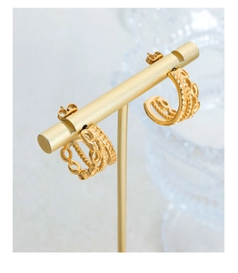 Close-up of triple-layered C-shaped gold-plated steel earrings on a display stand