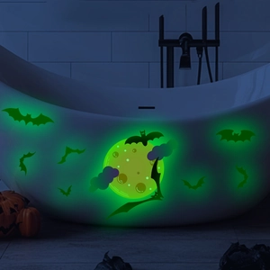 Green glow in the dark Halloween bat and moon stickers on bathtub in dark room