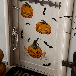 Detail of Halloween pumpkin and bat wall stickers applied on a light wood door