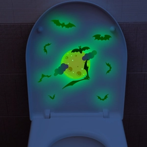 Luminous Halloween wall stickers featuring green glowing bats and moon on a dark toilet lid