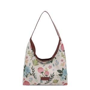 Floral canvas tote bag with brown faux leather trim and top handle on white background