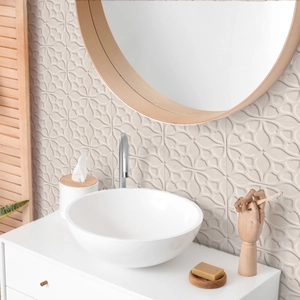Detailed view of geometric embossed wall tiles behind a modern white ceramic basin