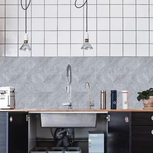 Detail of grey marble self-adhesive wall tiles applied on kitchen backsplash