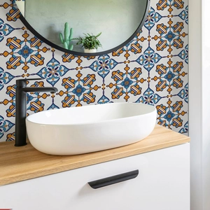Close-up of white ceramic oval basin on wooden vanity with vintage floral tiles