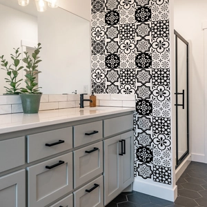Detail view of black and white mandala tile stickers applied on a bathroom wall background