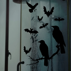 Detail van Halloween raamstickers met zwarte vleermuizen en een kraai op een takje
