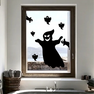 Detail van zwarte spook-silhouetten aangebracht op een raam met uitzicht op het meer