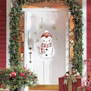 Close-up of a festive snowman wall sticker with green snowflakes on a white door