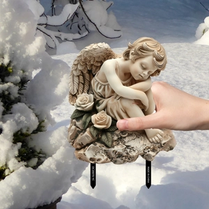 Detail of garden angel stake featuring a stone-textured cherub with roses and ground spikes