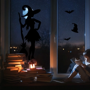 Detail van Halloween raamstickers met heks en vleermuis silhouetten op glazen wand