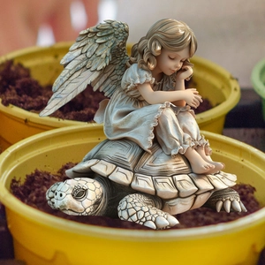 Detailed close-up of vintage resin angel sitting on a turtle garden statue ornament