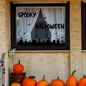 Detail of spooky Halloween window decals with bats and graveyard silhouette on glass