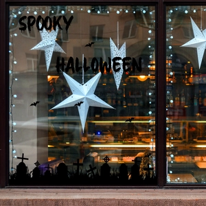 Close-up of Halloween silhouette window decals featuring spooky graveyard and bats