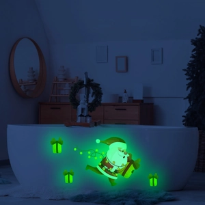 Luminous Santa Claus and gift box wall stickers glowing green in a dark room setting