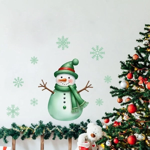 Close-up of mint green glowing snowman and snowflake wall stickers in a cozy room
