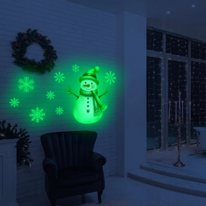 Luminous Christmas snowman and snowflake wall stickers glowing green in a cozy room decor